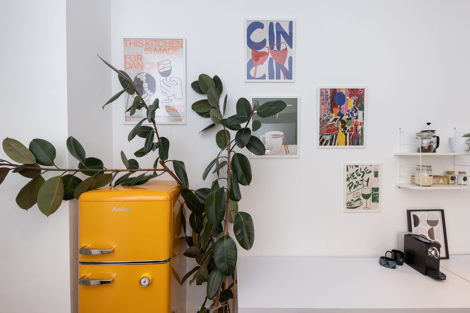 Detail Kueche mit gelbem Kuehlschrank und Kunstprints