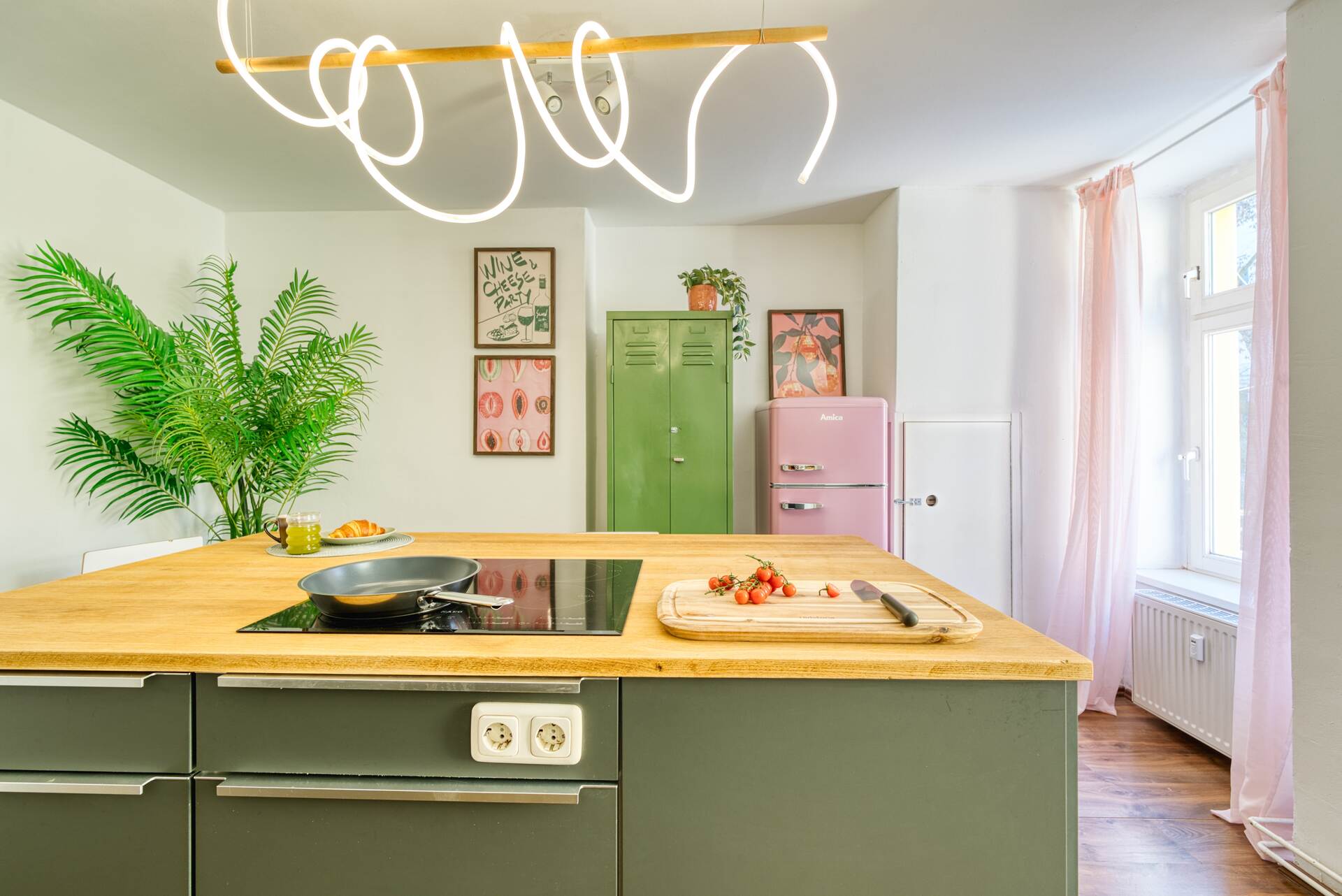 Bunte Küche mit Kücheninsel und rosa Kühlschrank