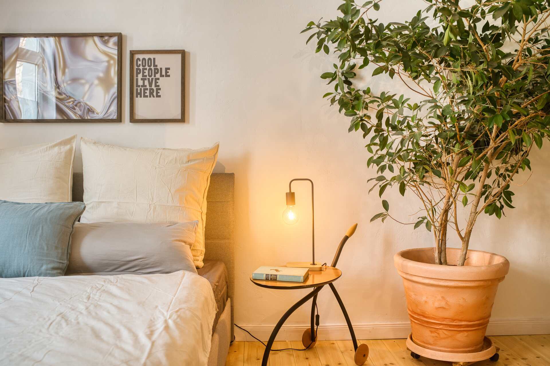 Schlafzimmer Detail mit Doppelbett und großer Pflanze