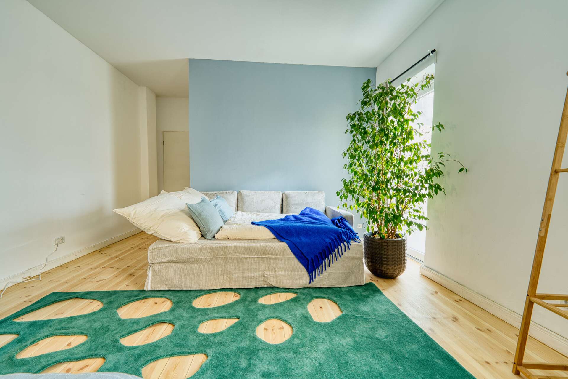 Schlafzimmer mit Blick auf Schlafsofa, besonderer Teppich