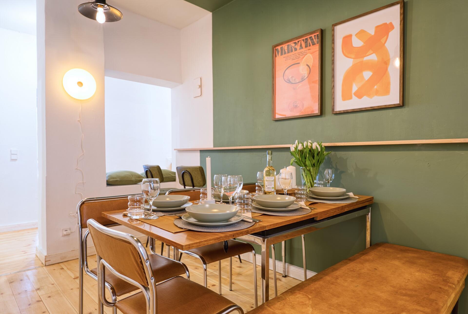 Orangene Kunst Prints auf grüner Wand im Essbereich