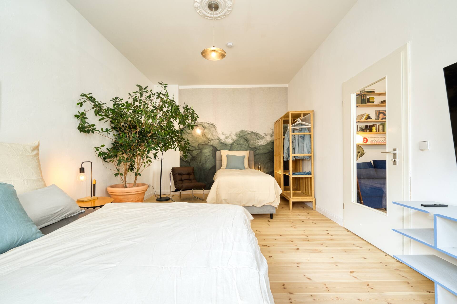 Schlafzimmer mit Einzelbett und Doppelbett und kreativer Tapete