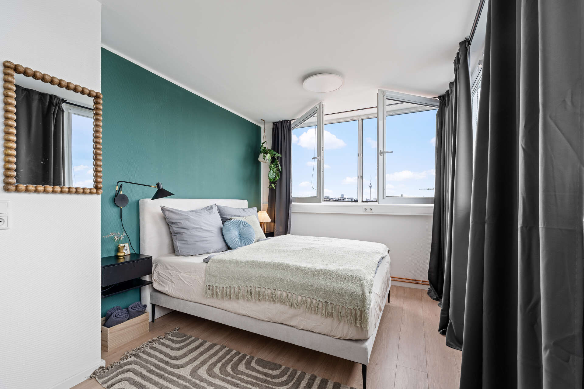 Schlafzimmer mit Bett und Aussicht und grüner Wand und Spiegel