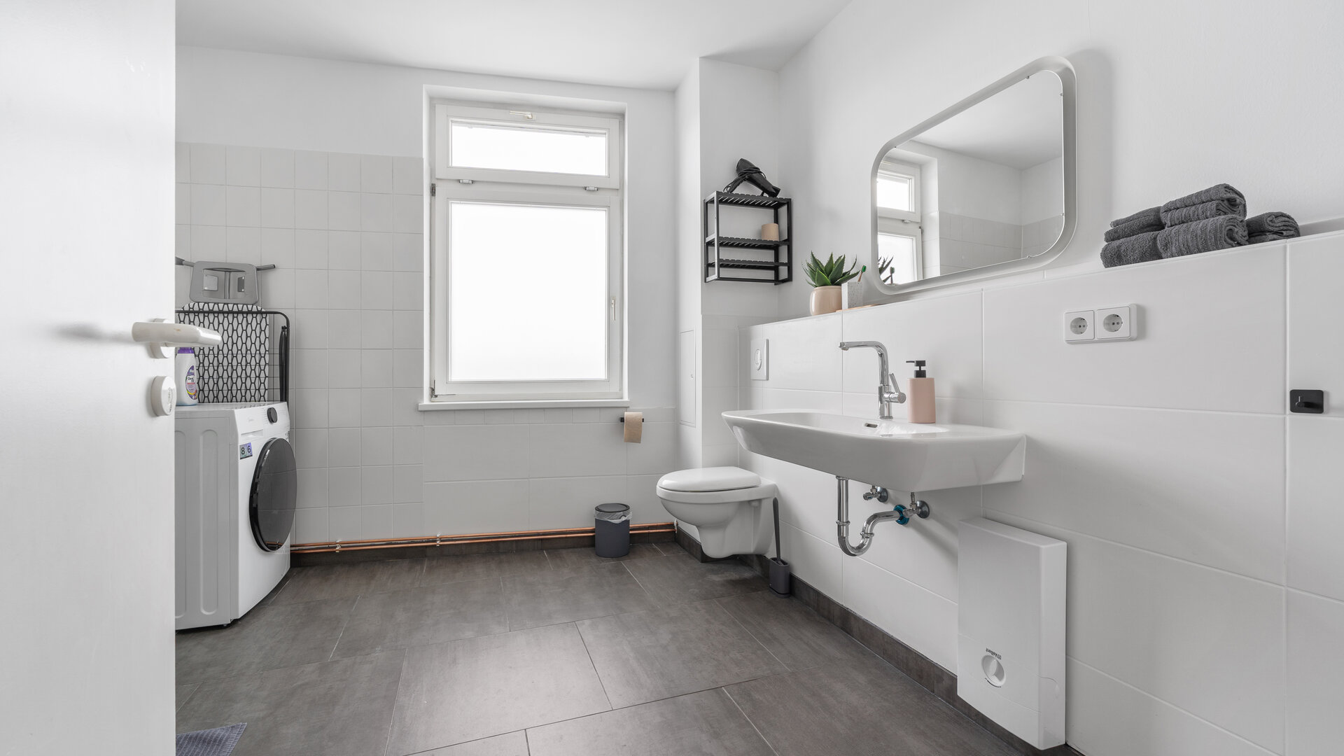 Badezimmer mit Waschmaschine und Dusche