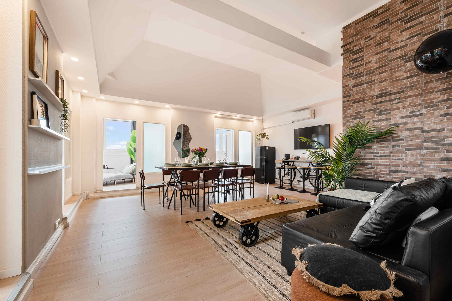 Wohnzimmer mit Essbereich und Türen zu den Schlafzimmer