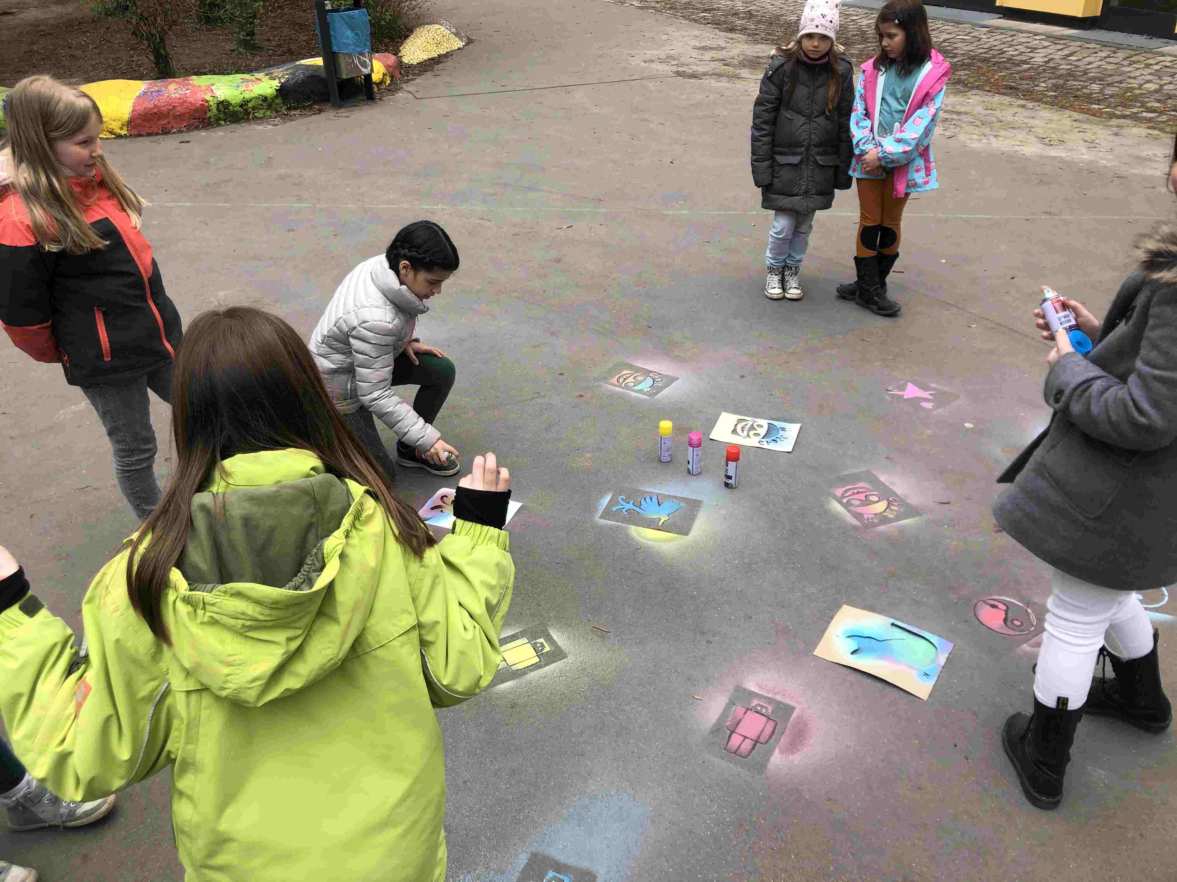 Kinder spielen auf der Straße und malen
