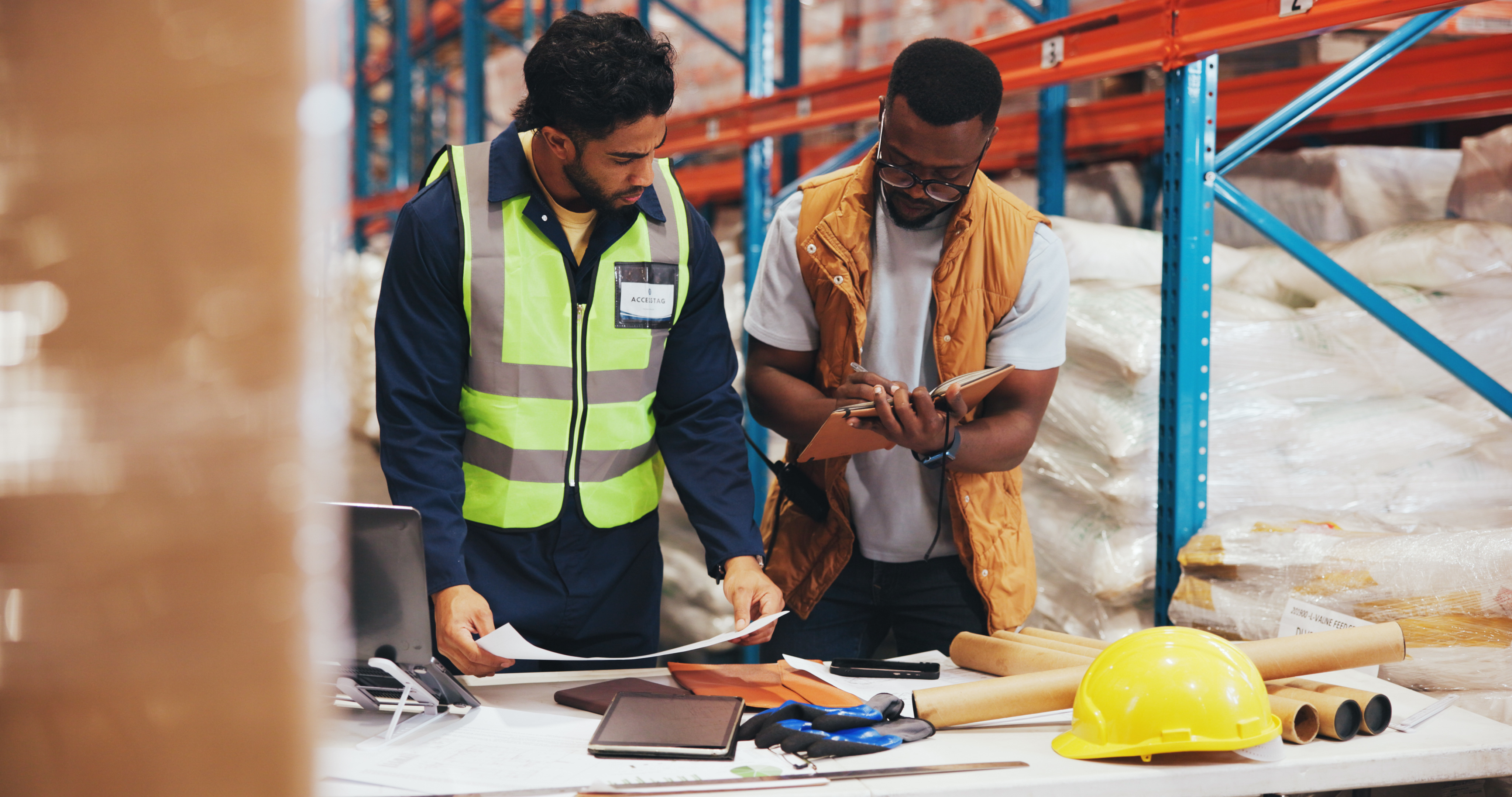 Supply chain team reviewing supplier options with a laptop in a warehouse