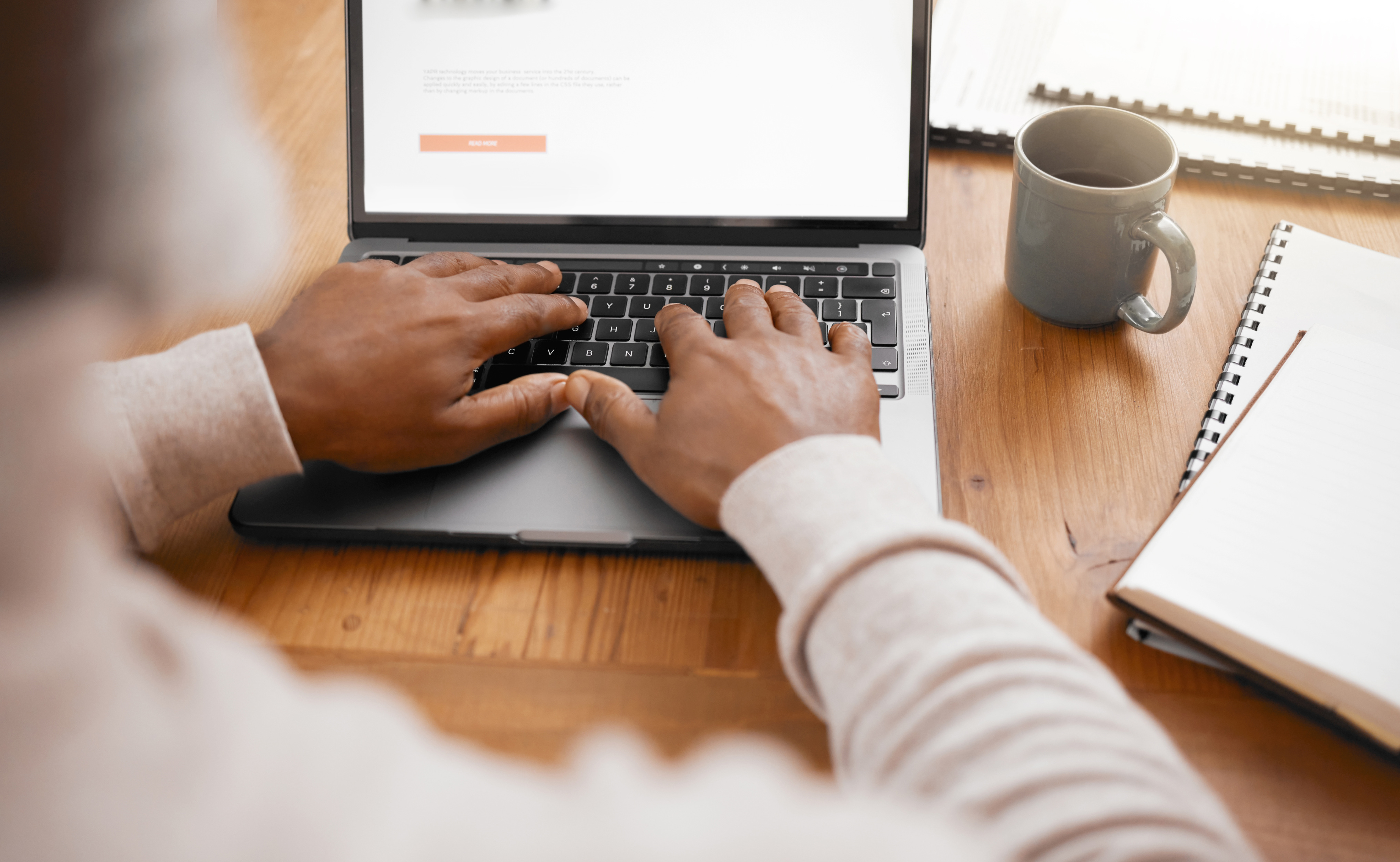 Professional writing a cold outreach email on a laptop at a desk