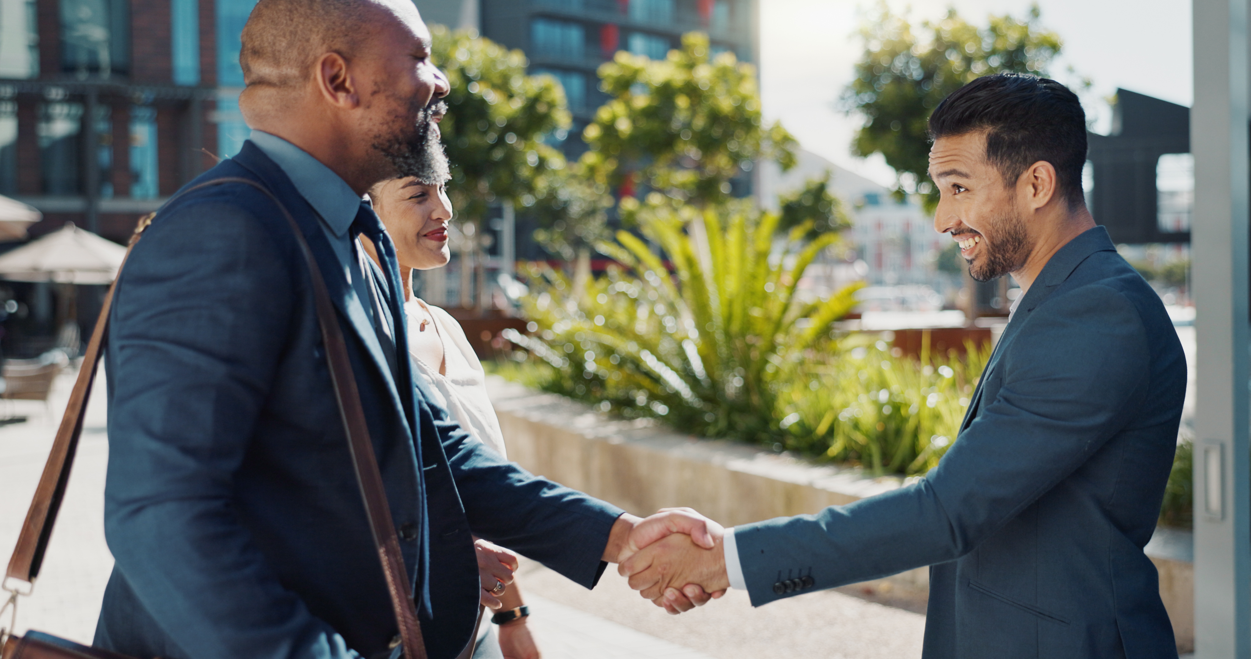 Business people meeting outdoors in a city, greeting with a handshake