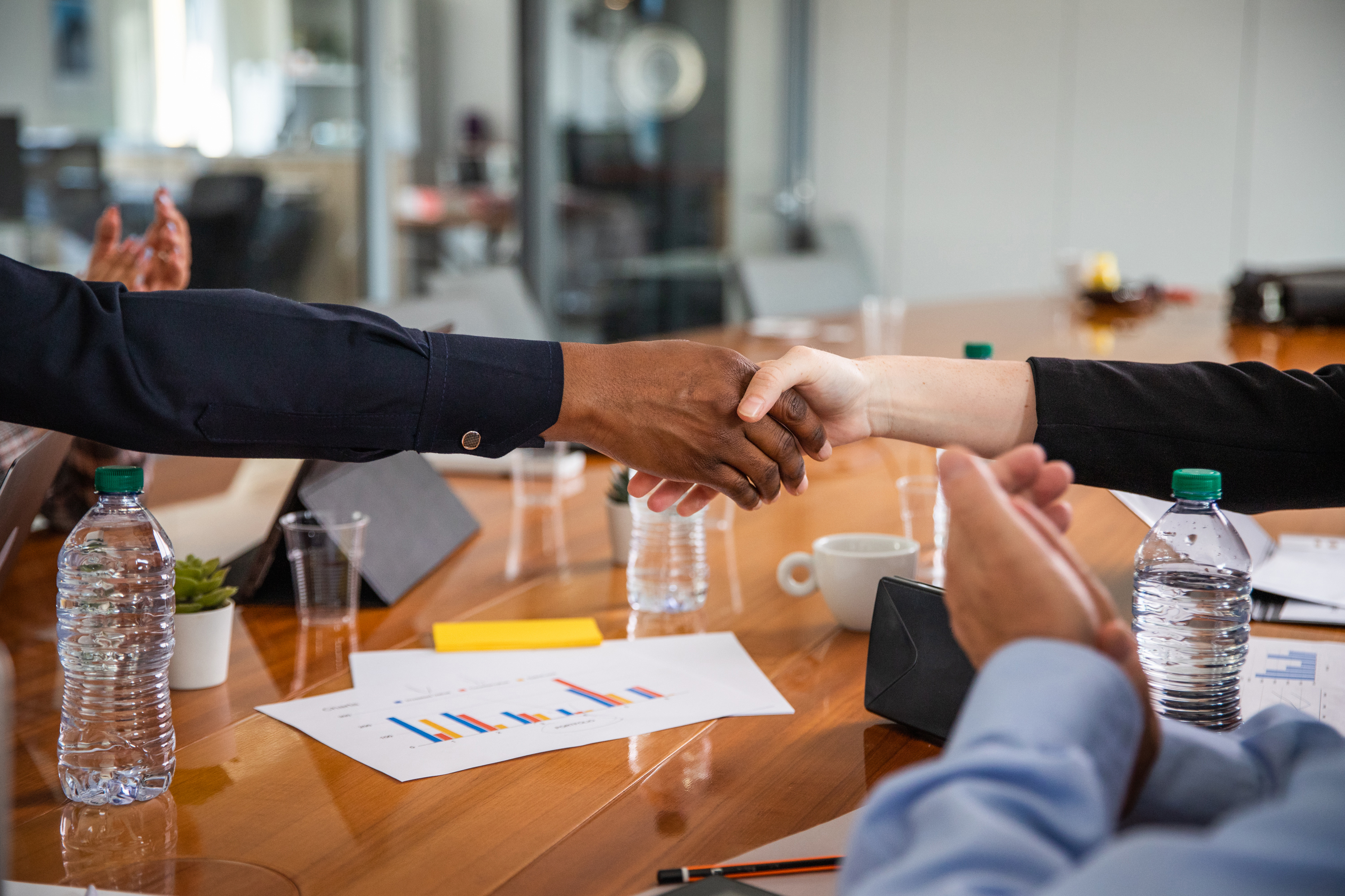 Two professionals shaking hands in a cross-cultural negotiation