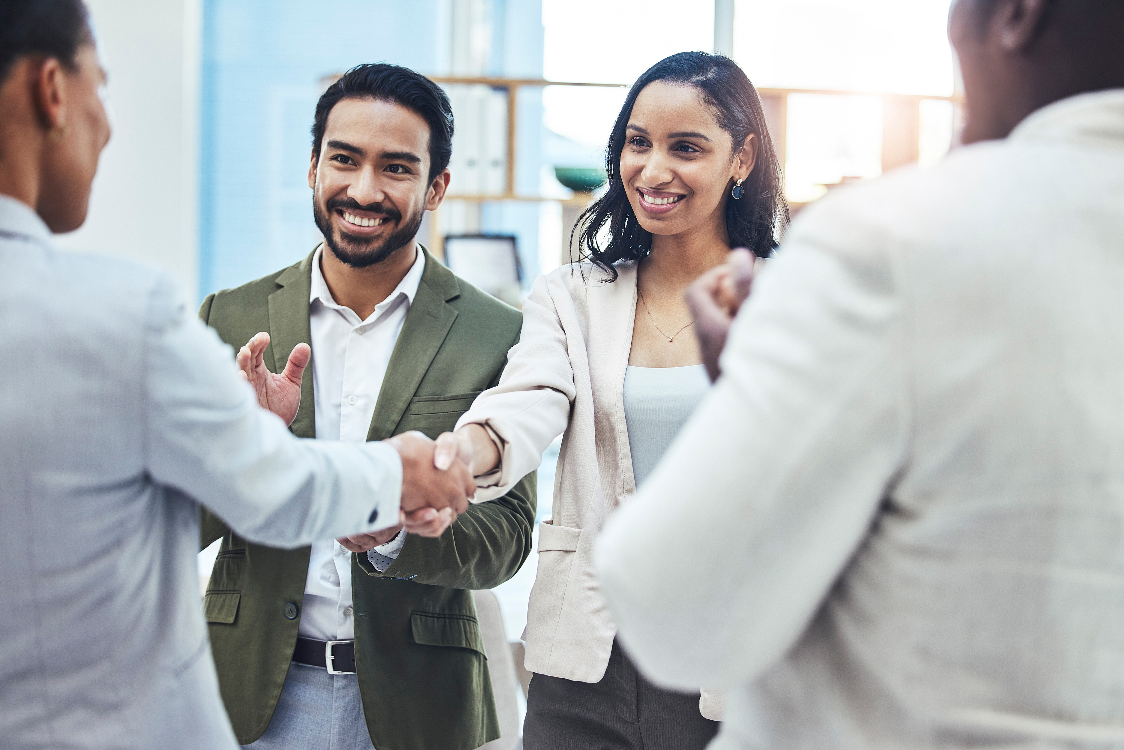 Bilingual sales team celebrating a deal in an office