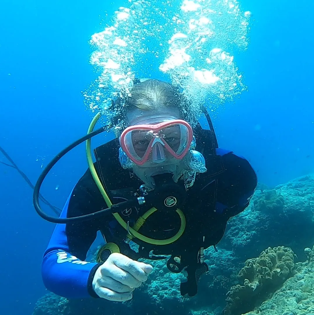 Kristina scuba diving above a coral reef