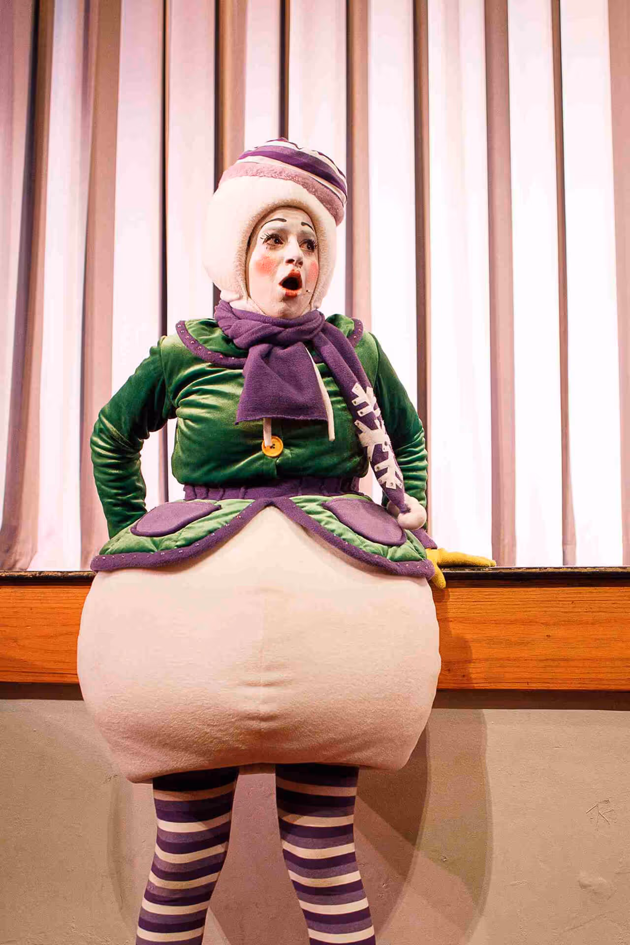 Actor in makeup wearing a snowman costume showing surprise on stage during a children's New Year show