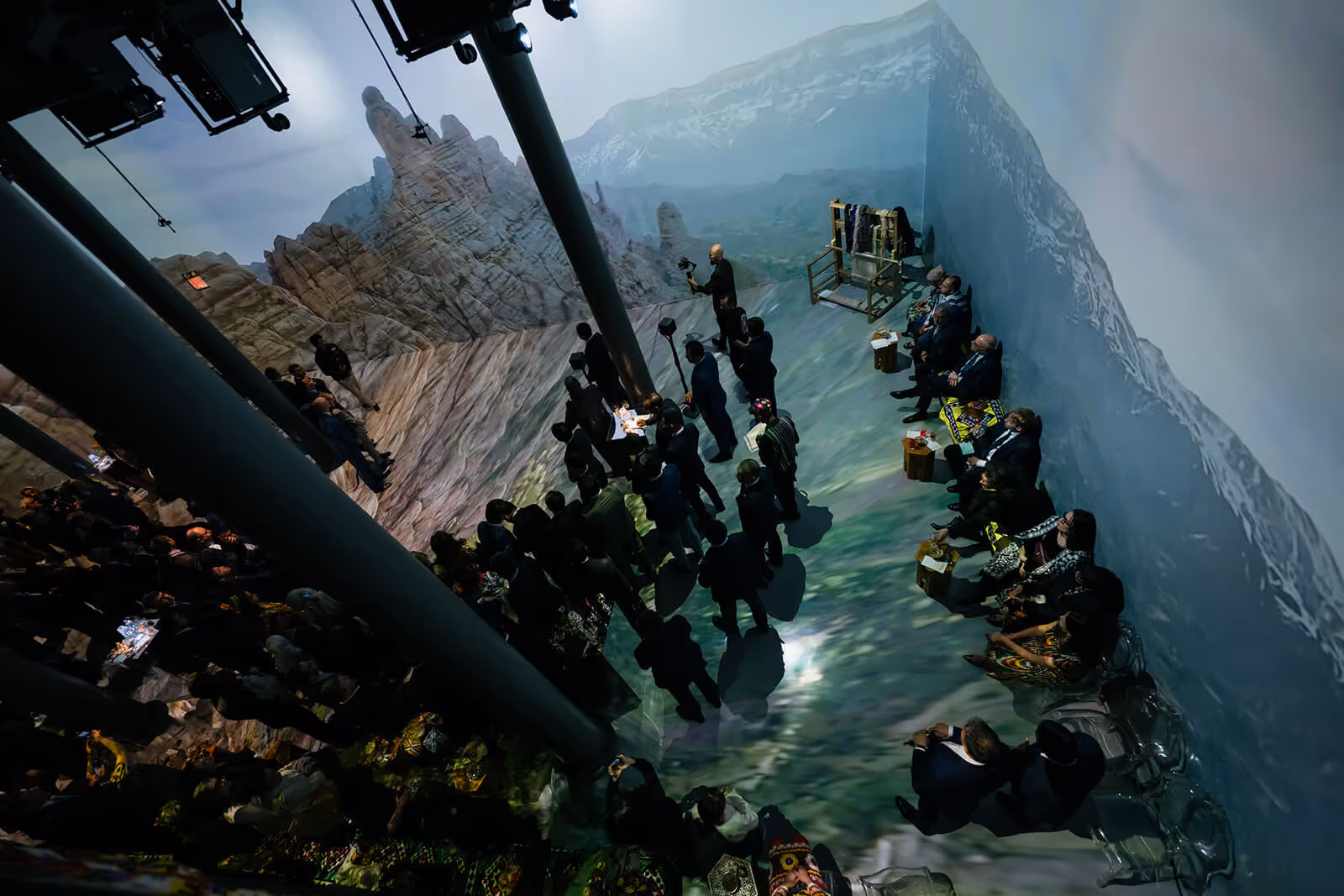 Threads of Tradition: crowd on projected mountain cliff with misty landscape.