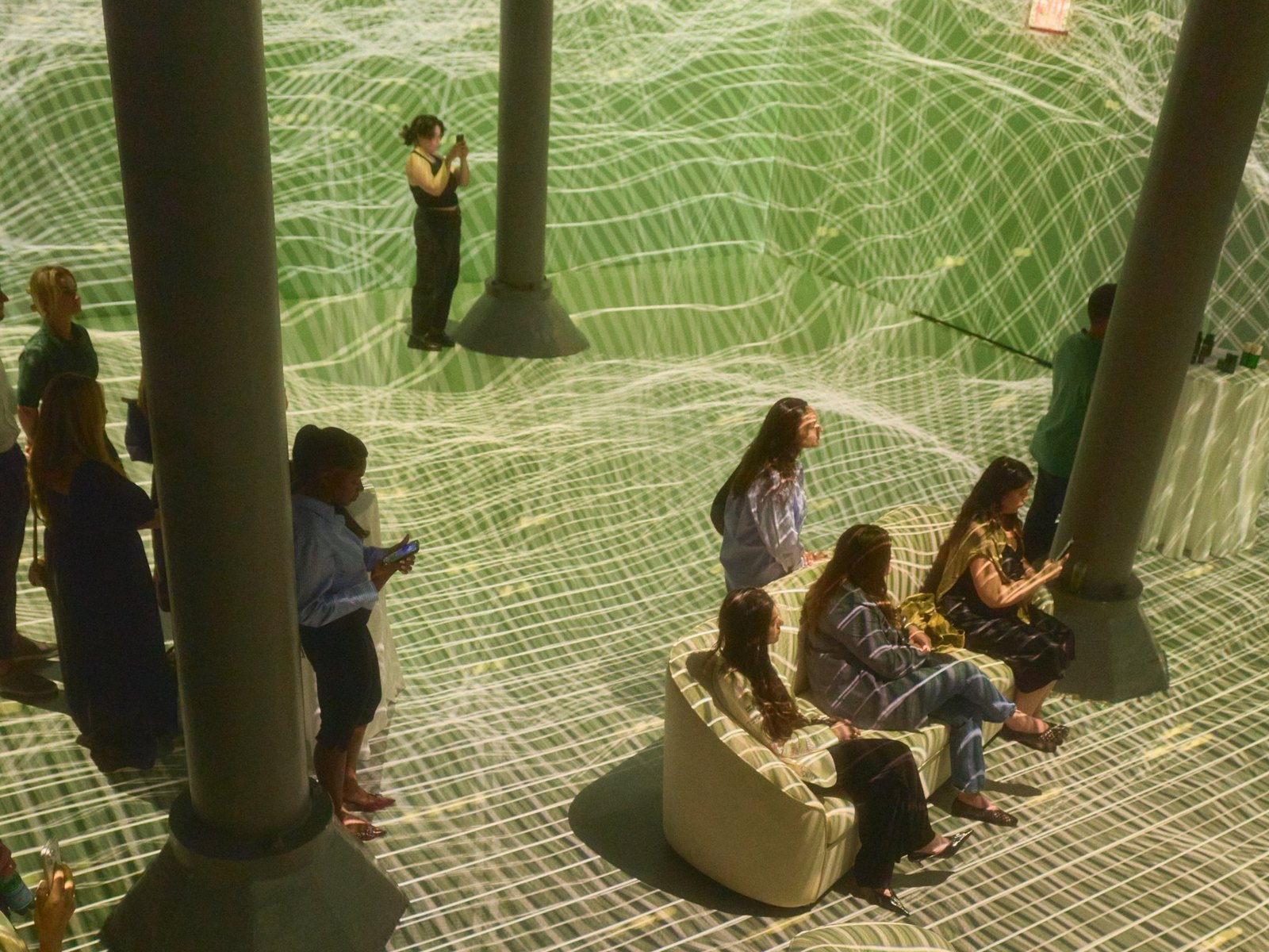 Top view of guests inside the projected topographic waves at ARTECHOUSE NYC