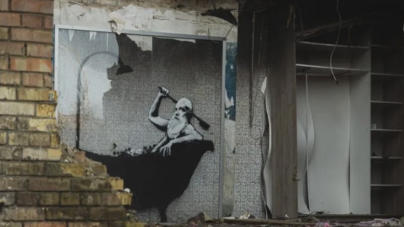 Mural of a man in a bathtub on the wall of a destroyed apartment