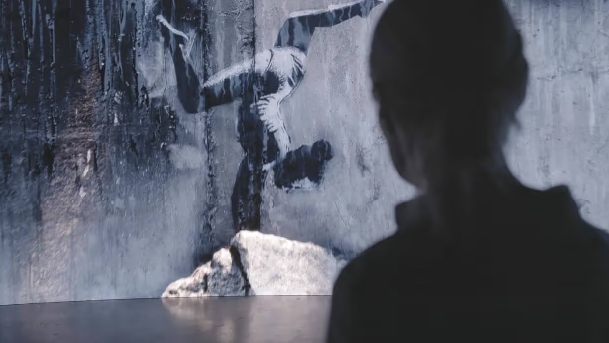 Visitor in front of a scanned mural wall inside the installation