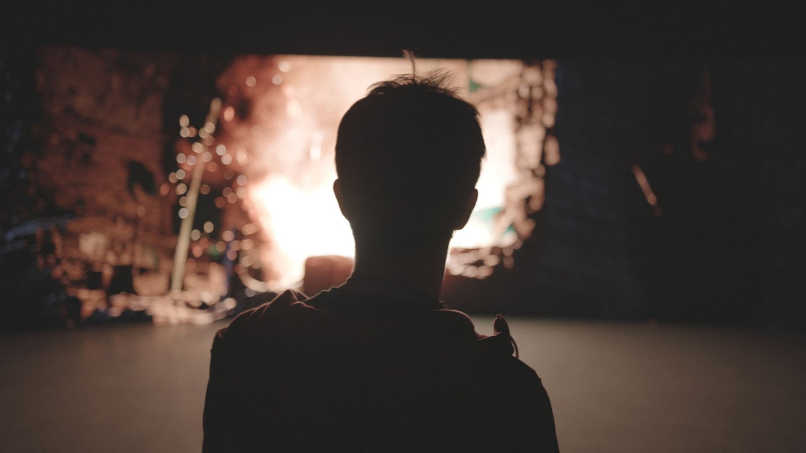 Silhouette facing a burning window in a scanned ruined interior
