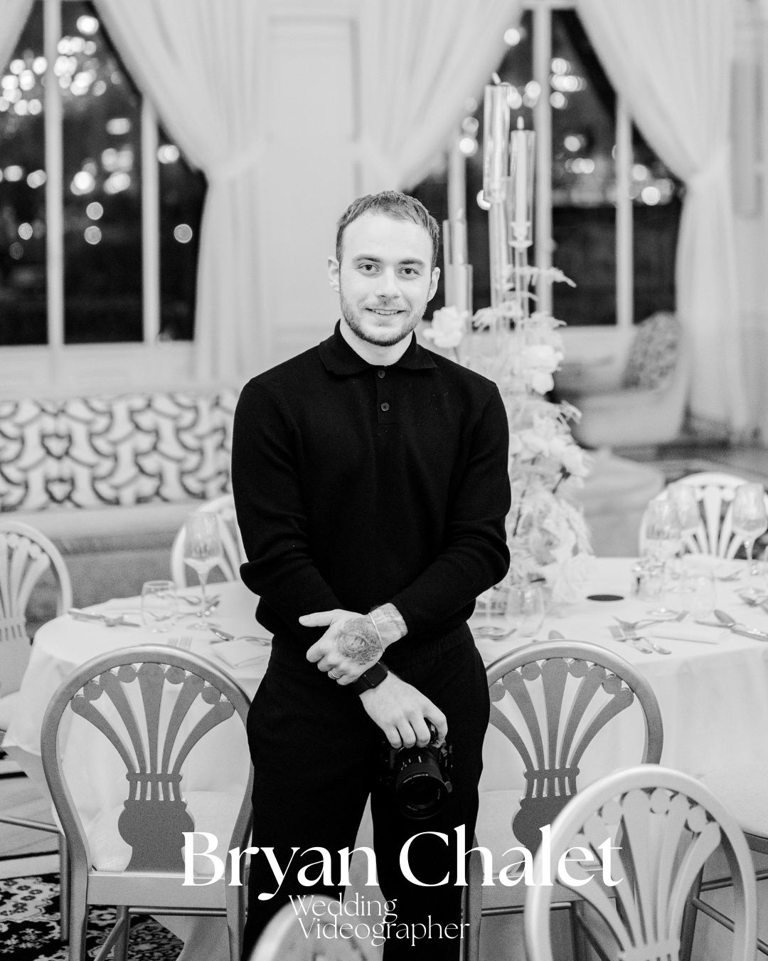 Picture of Bryan Chalet (Bynyx) holding a camera, standing in an elegant dining room with decorated tables and chairs.