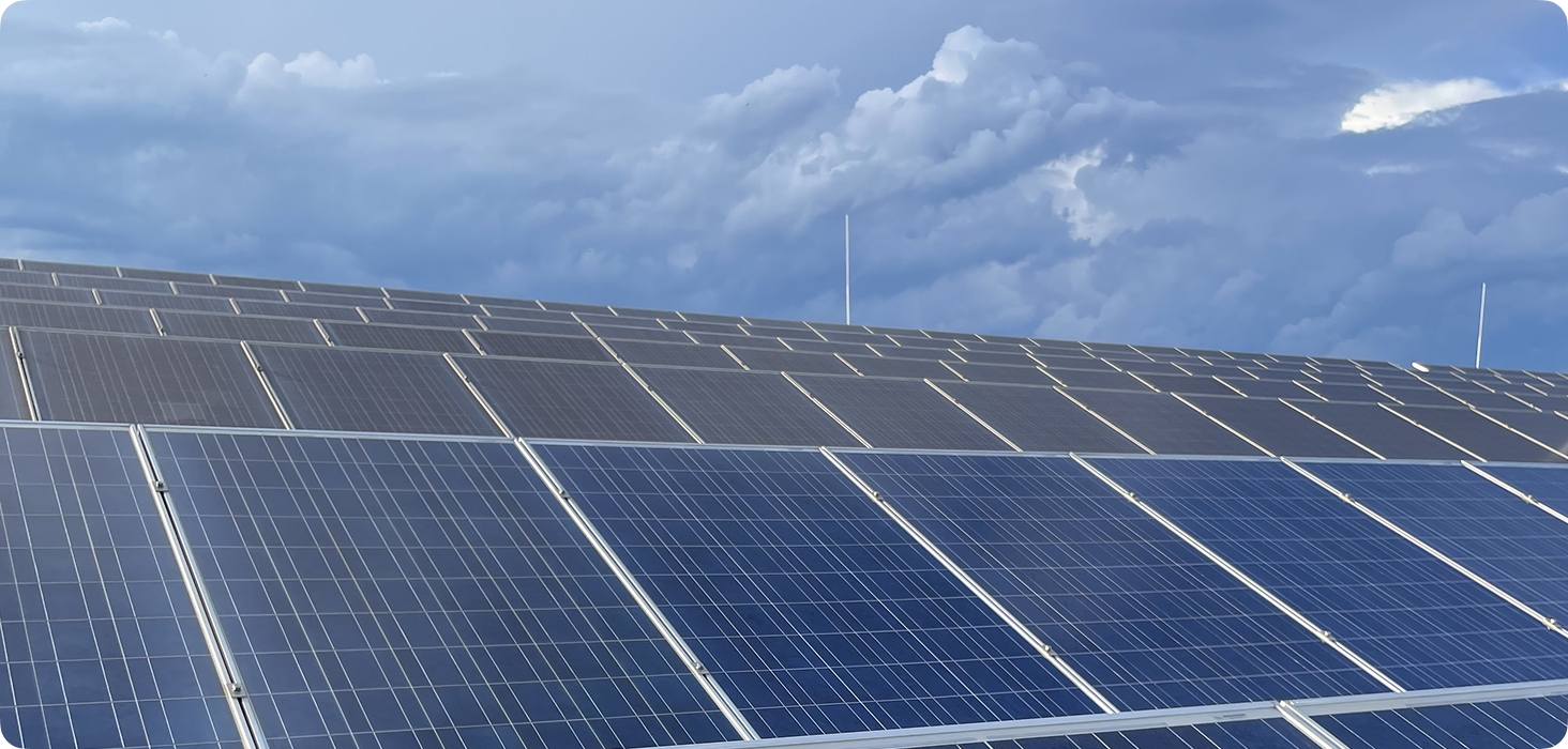 Solar panels installed outdoors under a cloudy sky for renewable energy generation and sustainability solutions.