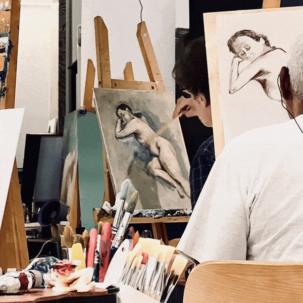 Artists painting charcoal and oil portraits of a reclining nude model in an art studio.