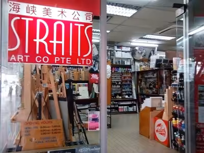 Interior view of Straits Art Co Pte Ltd showing easels, painting supplies, and art materials on shelves inside the store.