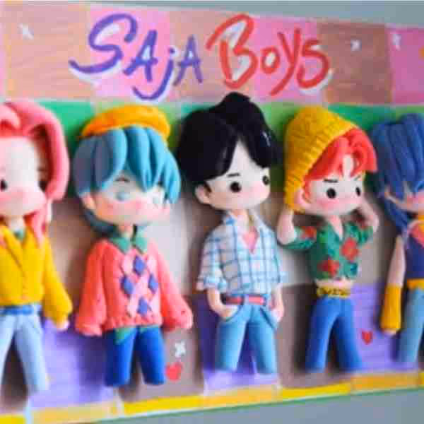 Colorful clay figures of five boys with various hairstyles and clothing standing in front of a background labeled 'SAJA BOYS'.