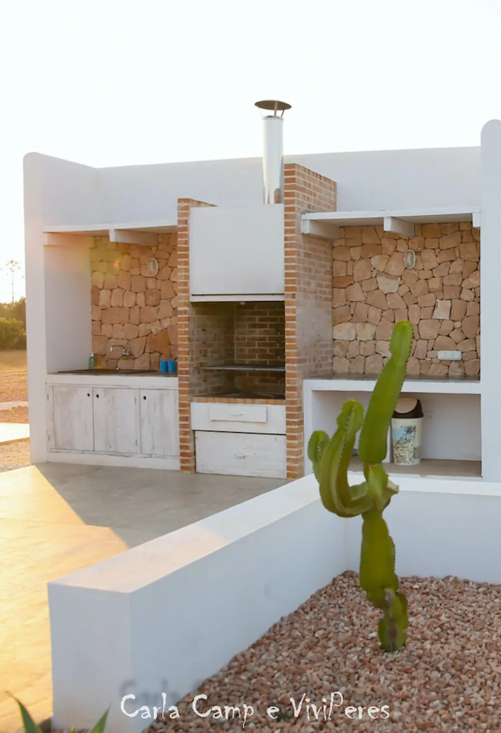 Zona de barbacoa de obra y cocina exterior construida en piedra y estilo rústico para asados.