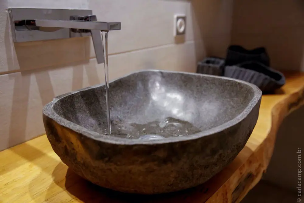 Detalle del lavabo de piedra artesanal en el baño en suite