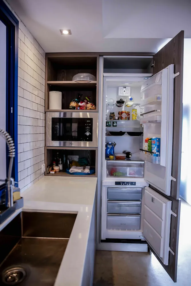 Despensa y frigorífico integrados en la cocina del alojamiento en Formentera