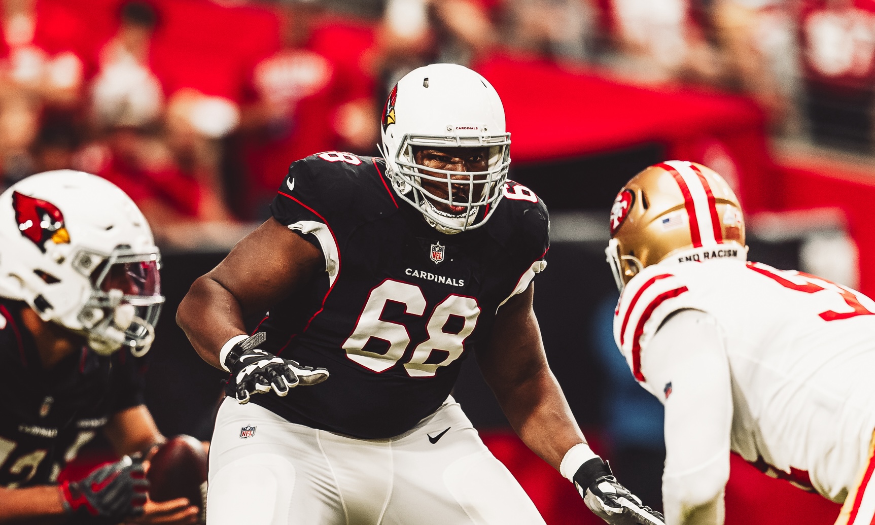 Kelvin, Arizona Cardinals football player number 68 in black jersey, facing a San Francisco 49ers player in white jersey during a game.