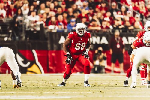 Kelvin in red Arizona Cardinals uniform, number 68, crouching on the field ready for play.