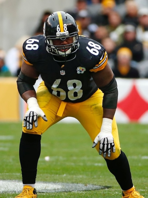 Kelvin in black and yellow Steelers uniform crouched on field in ready position.