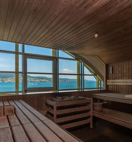 Holmes Place-Sauna mit Holzbänken, Meerblick und großen Fenstern zur Entspannungstherapie.