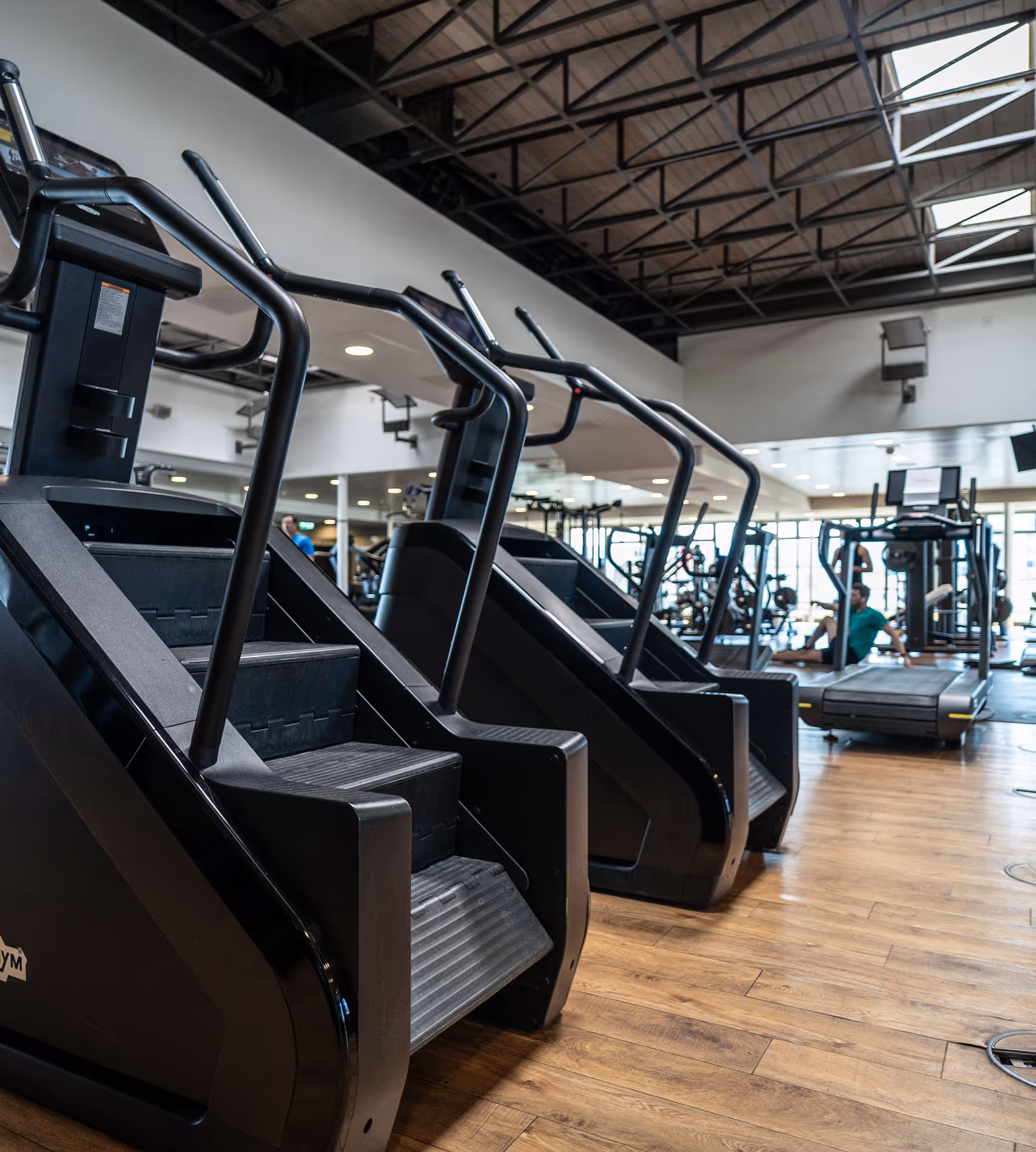 Innenansicht der Fitnesseinrichtung von Holmes Place mit Stairmaster-Laufbändern für Cardio-Training