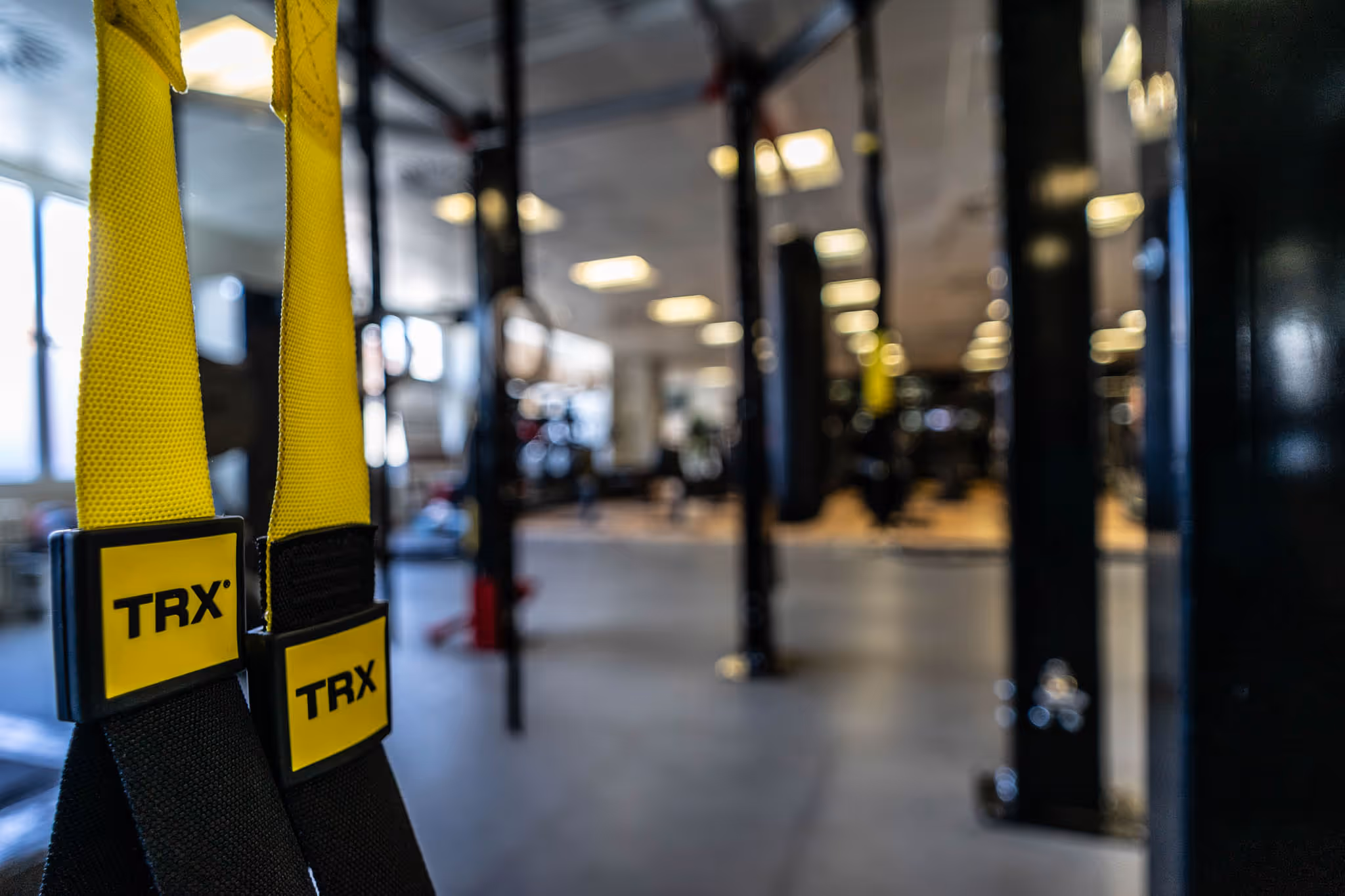TRX-Schlingen im Holmes Place-Fitnessstudio, die die Farben und das Design der Marke hervorheben.