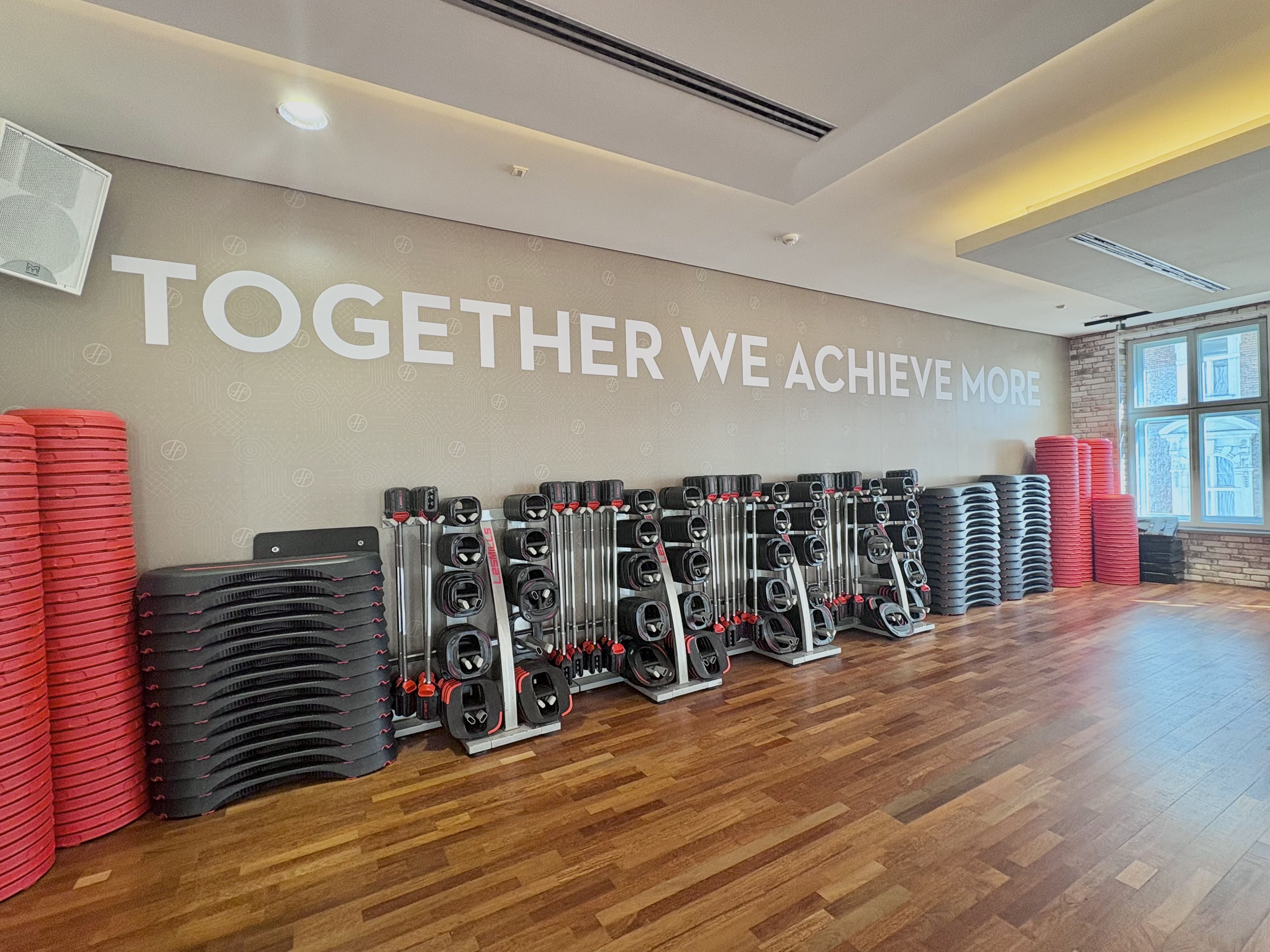 Das Fitnessstudio von Holmes Place ist mit Trainingsgeräten ausgestattet und an der Wand hängen motivierende Zitate.