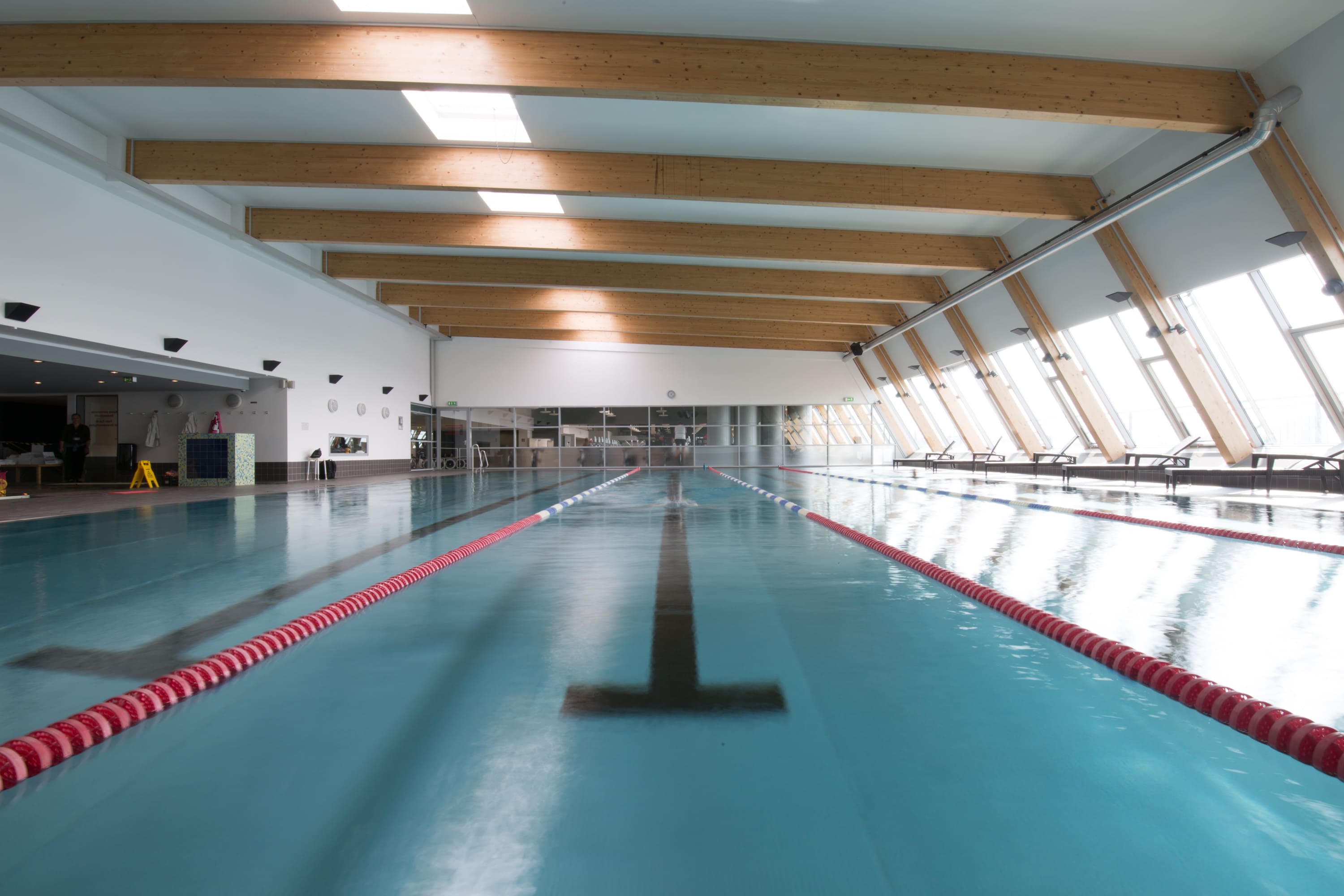 Das Hallenbad von Holmes Place verfügt über Tageslicht und Holzbalken.