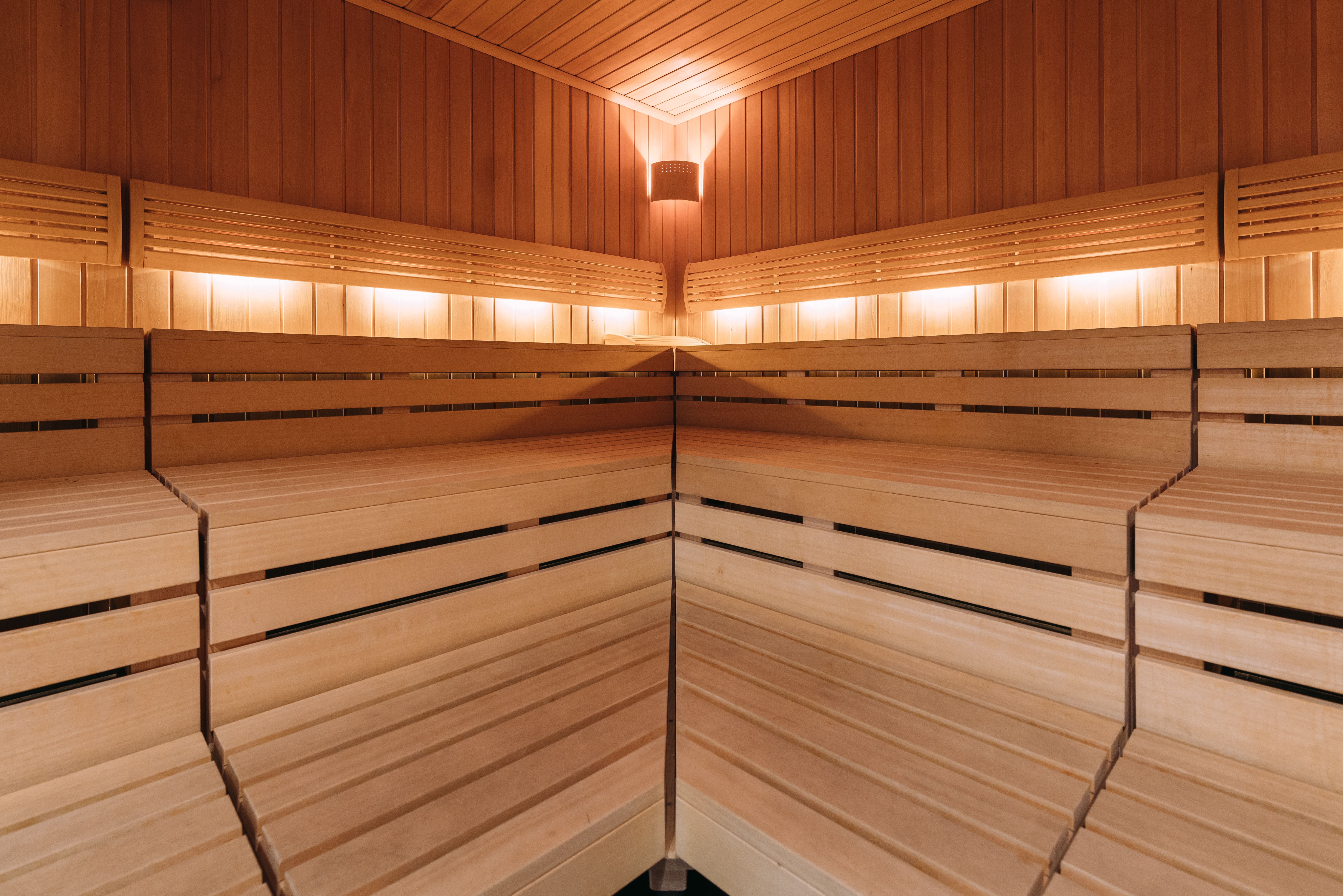 Innenansicht einer modernen Sauna mit warmen Holztönen und gedämpftem Licht