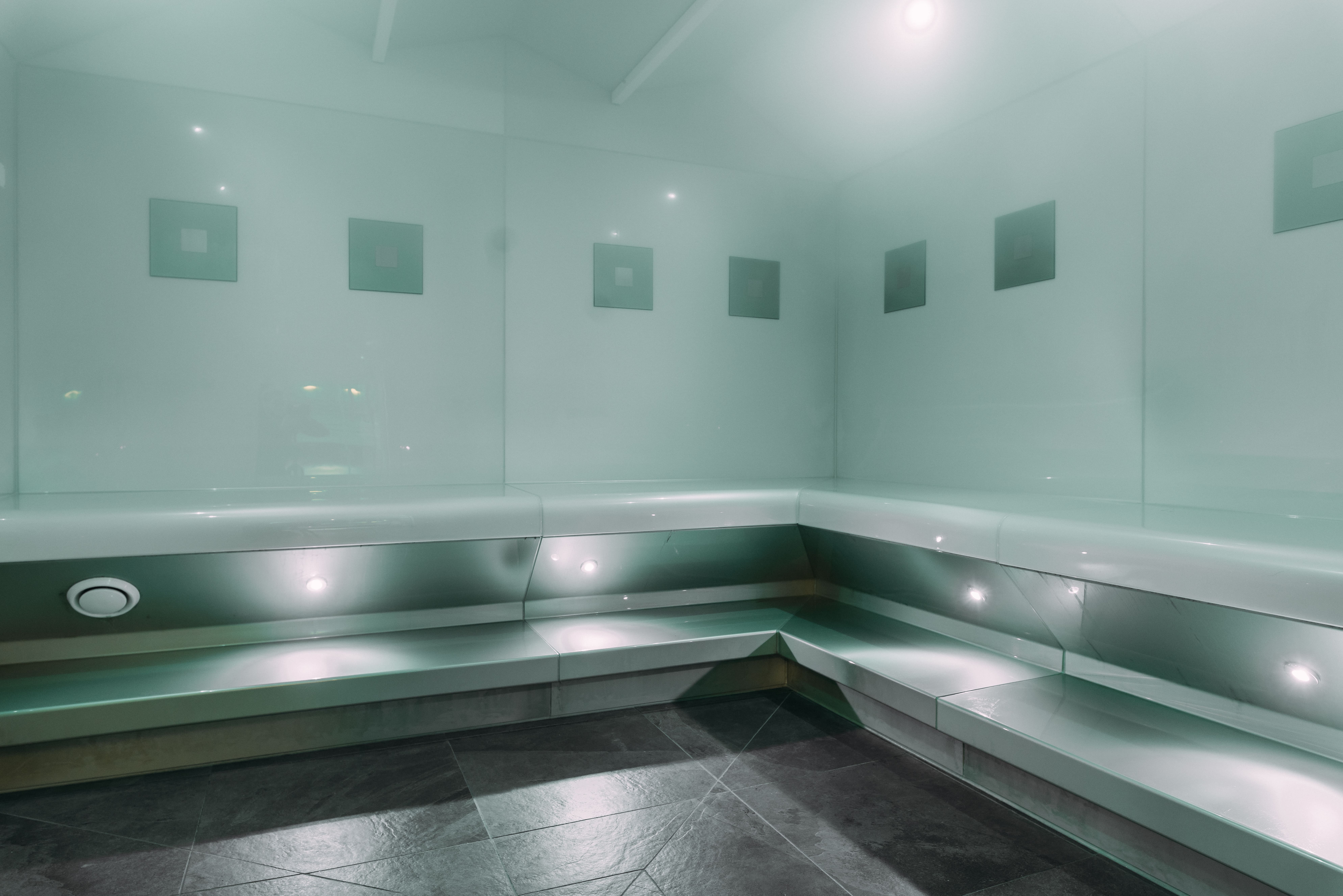 Moderner, minimalistischer Raum mit grünem Glas und eingebauter Beleuchtung