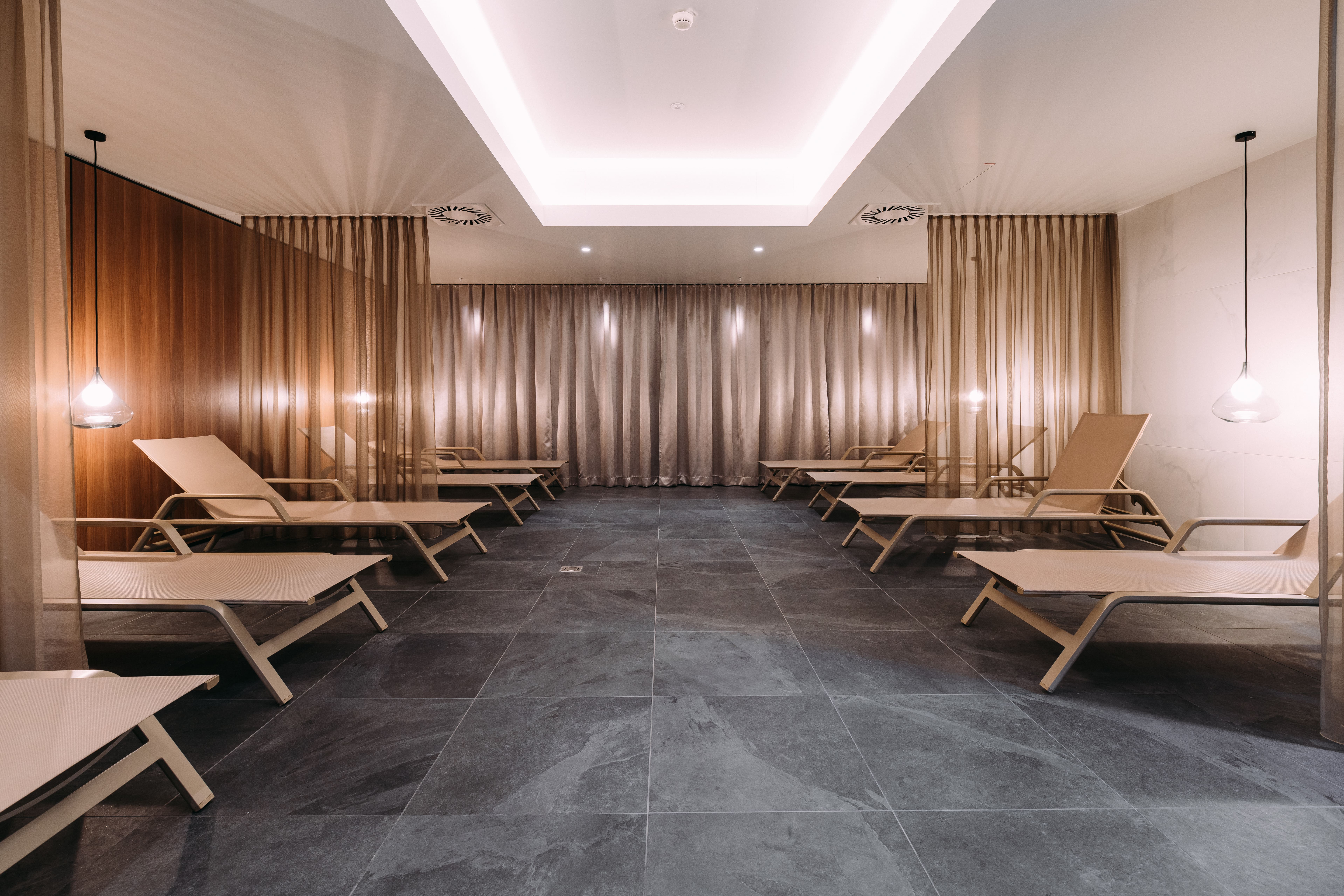 Moderner Ruheraum mit Sonnenliegen und gedämpftem Licht