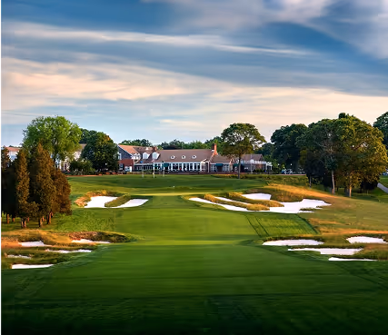 Pristine golf course with sand bunker, green fairway, and blue sky