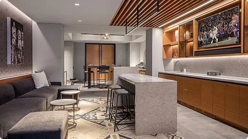 Modern luxury suite with basketball artwork, kitchen, and lounge area