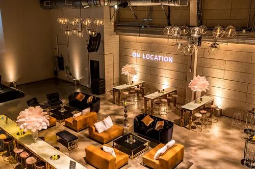 Stylish lounge with orange sofas, globe lights, and feathered lamps