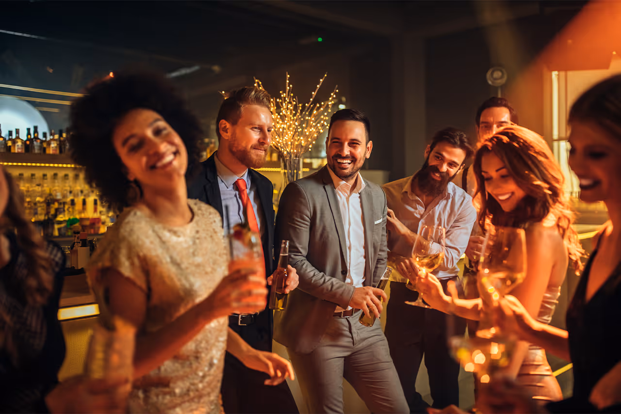 Festive group of colleagues enjoying drinks at a glittering bar