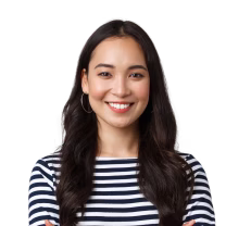 Smiling young woman with long dark hair wearing a striped shirt with arms crossed.