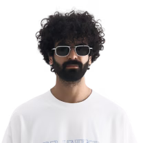 Man with thick curly hair and beard wearing sunglasses and a white shirt.