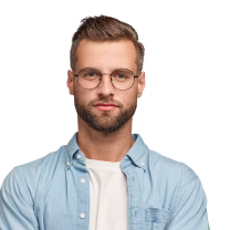 Portrait of a man with short hair, beard, and round glasses wearing a light blue button-up shirt over a white t-shirt.