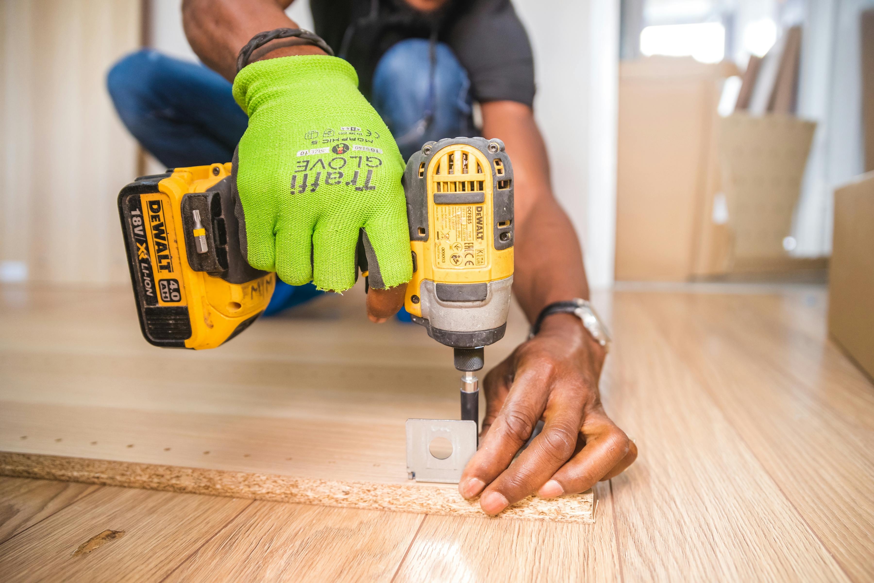 hands drilling nail into wood