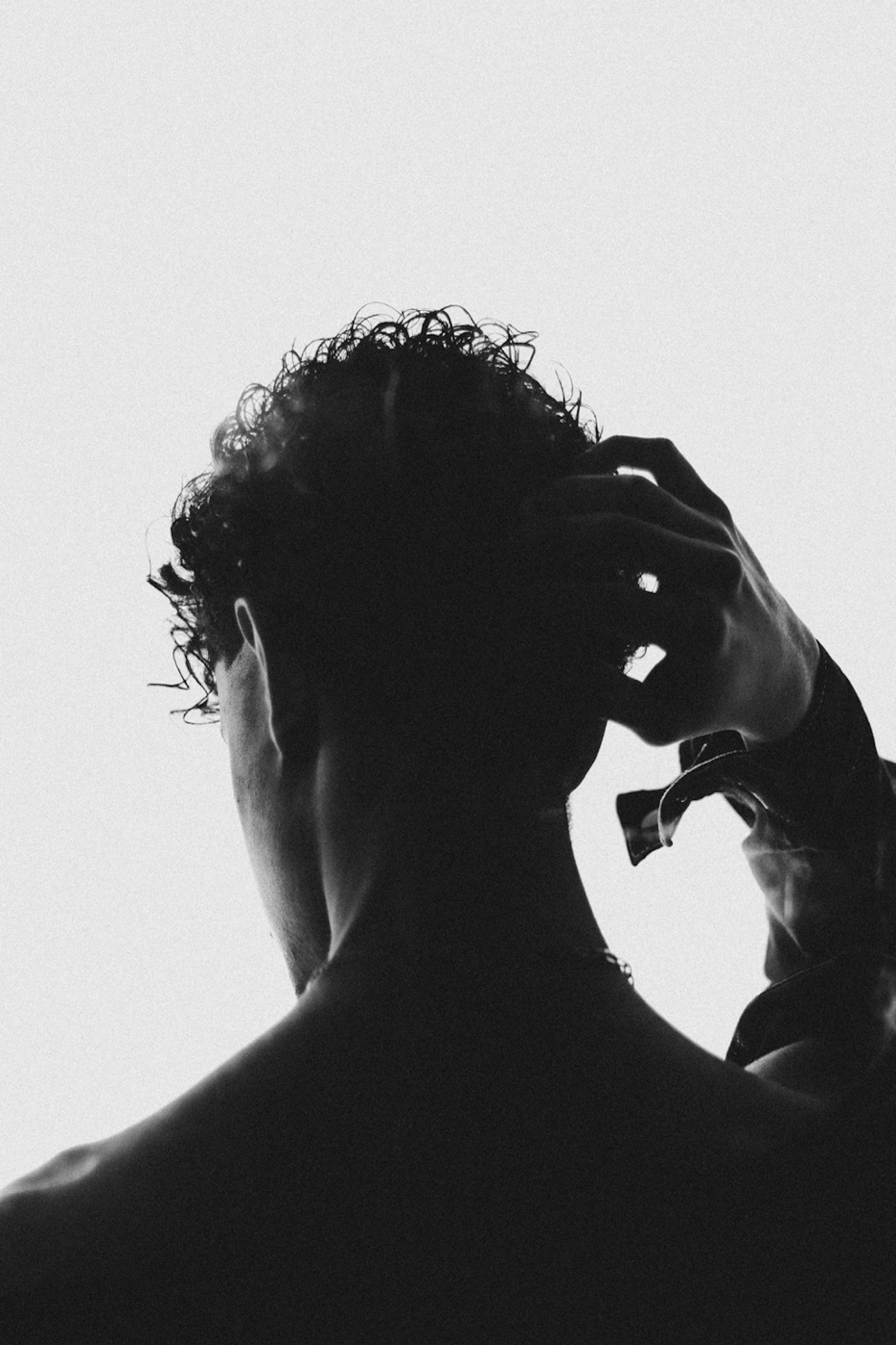 homme se touchant les cheveux (vue arrière) après une greffe capillaire 